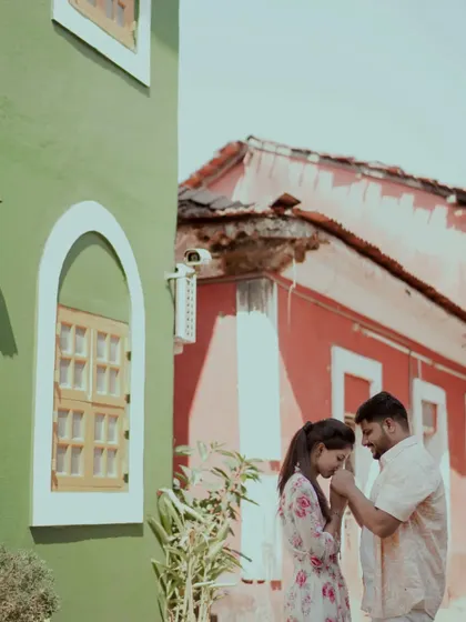 A classic romantic gesture. He gently kisses her hand in the charming lanes of a coastal town.