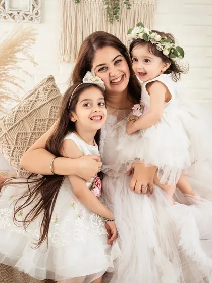 A mother and her two daughters, all smiles and cuddles. A portrait overflowing with love.