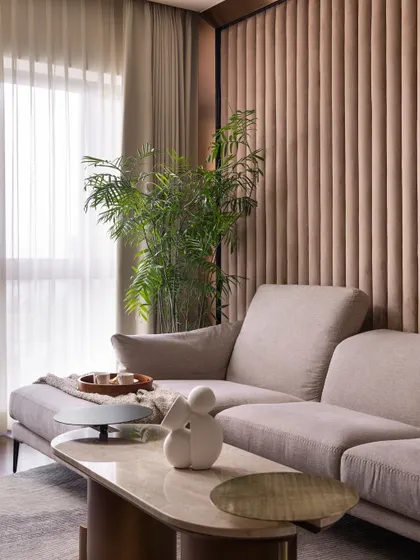 This close-up shows the soft, inviting texture of the sofa and the elegant marble-topped coffee table, creating a perfect corner for relaxation.