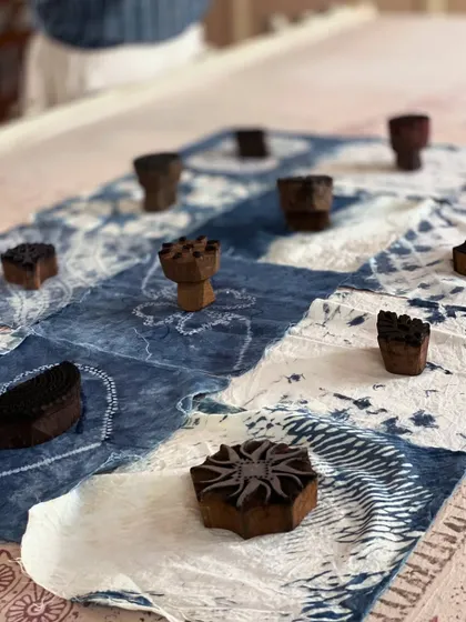 A layout of wooden blocks on an indigo-dyed fabric, announcing our upcoming workshops in Bengaluru. We partner with local spaces to share the art of natural dyeing.