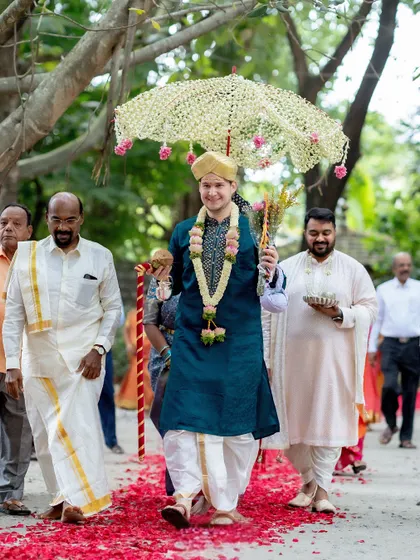 Our groom, Patrick, making his entrance in a traditional 'Kashi Yatra' ritual. We guide our international clients through every step of the Indian wedding ceremonies, ensuring they feel comfortable and joyful.
