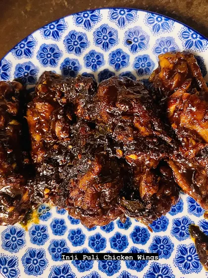 A close-up of the finished Inji Puli Chicken Wings. The glossy, dark sauce clings to every piece, promising a punch of sweet, sour, and spicy flavor.