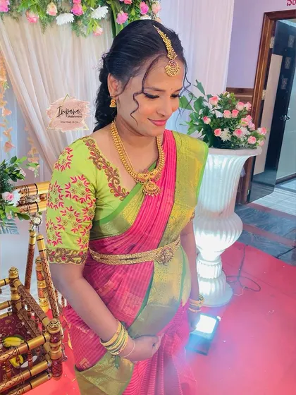 A lovely shot of the mother cradling her bump during the naming ceremony. The soft makeup and traditional attire are perfect for this family event.