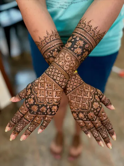 Another crossed-arm view, showing the intricate lotus and floral patterns on the back of the hands.