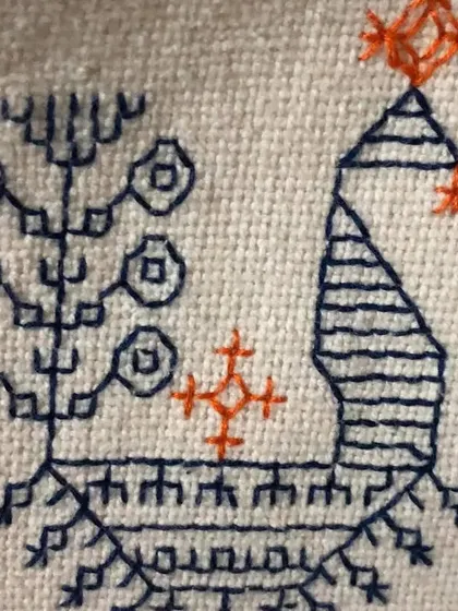 A close-up of a stylized peacock and tree motif done in Kasuti. This demonstrates how the simple running stitch can be used to create figurative and symbolic patterns.
