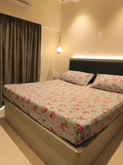 A bedroom with a light wood bed frame and a headboard with integrated backlighting, creating a soft and relaxing ambiance.