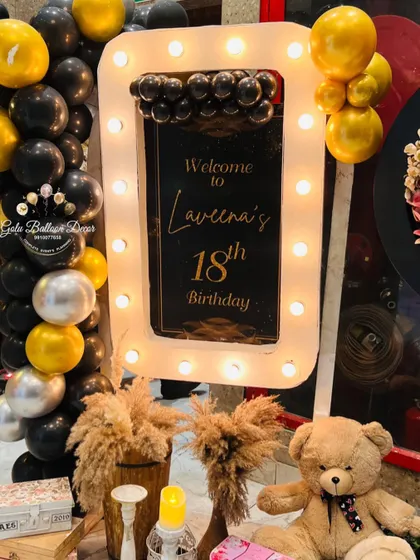 A glamorous welcome sign for an 18th birthday party, framed with lights like a vanity mirror.