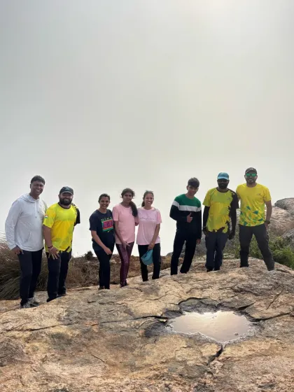 A group of friends posing at the summit on a foggy day. Even without a clear view, the sense of accomplishment and camaraderie is just as strong.
