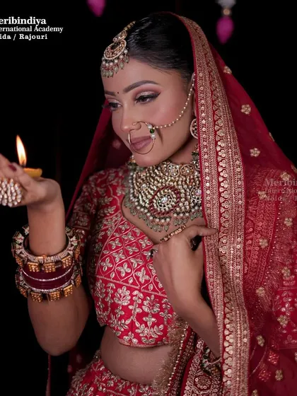 The bride holding a diya, with her hair elegantly styled in a classic bun, a timeless choice for traditional ceremonies.
