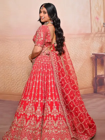 A back view showing the detailed hairstyle and the flow of the bridal lehenga.