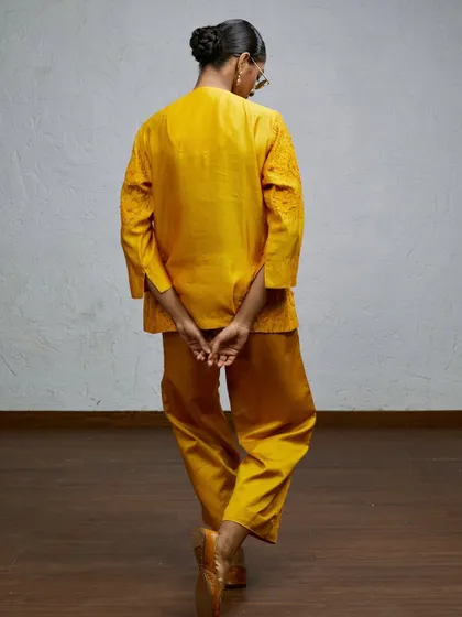 A back-facing shot that highlights the fit and design of this yellow co-ord set. This unconventional angle is great for showing different aspects of a garment that a standard front-facing shot might miss.