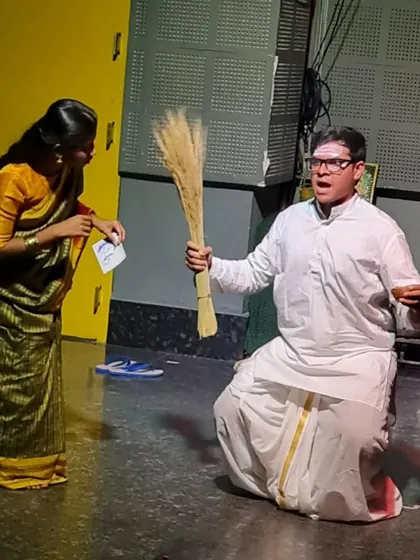 A student actor in a comedic role from "The Good Doctor," holding a broom with dramatic flair.