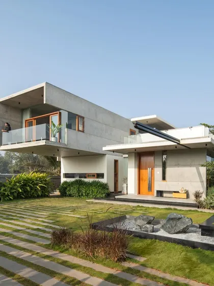 The Quarry House's composition of cantilevered volumes and open green spaces, viewed from the garden.