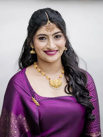 A close-up of the bride's Oorkuduva look. Her hair is styled in soft waves, and her makeup is modern and fresh.
