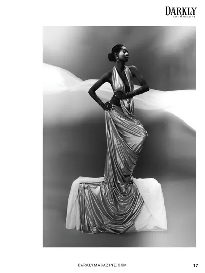 The beauty of this shot is in the contrast of light and shadow, with the sleek hair and makeup providing a focal point against the flowing white fabric.
