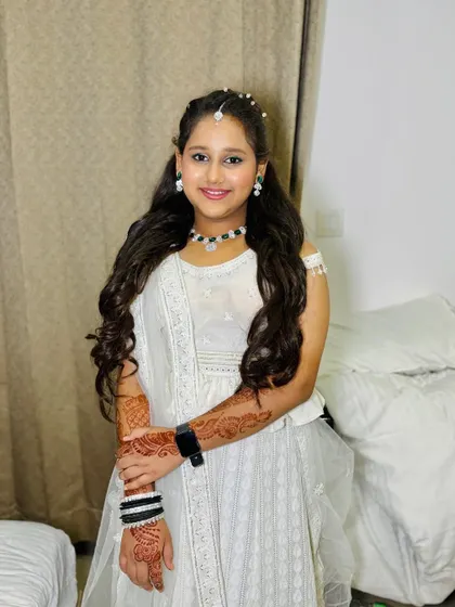 A full-length view of her pretty white outfit and complementary makeup.