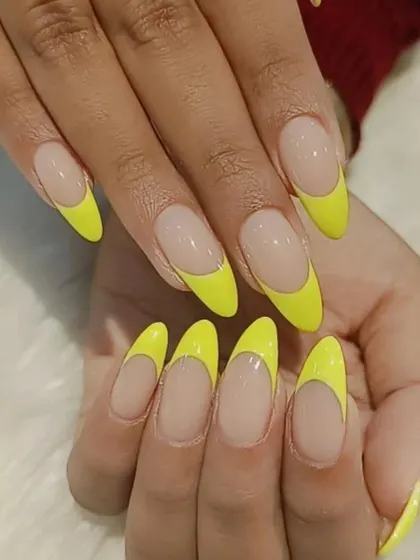 For a bold and fun look, we created this deep French manicure with a vibrant neon yellow tip on long almond nails.