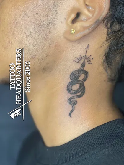 A classic gold stud in the earlobe. This client also got a fine-line snake tattoo on their neck, showcasing how we can help you combine different forms of body art.