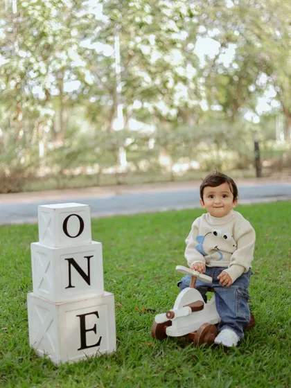 A sweet portrait of the one-year-old boy with his props in the park.