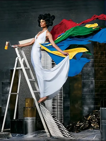 A conceptual fashion shoot where the model becomes a living work of art. The flowing colors and artistic set design transform a simple white dress into a canvas, creating a surreal and beautiful image.