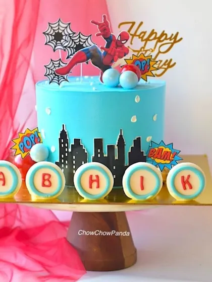 A closer look at the details on the Spider-Man cake, showing the personalized "ABHIK" discs and the action-packed toppers.