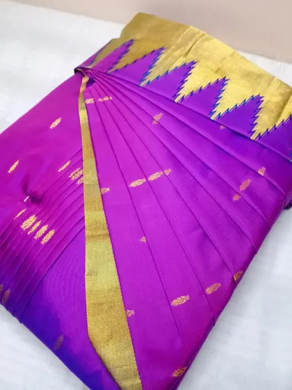 A stunning purple saree with a unique temple border. The pleats are set to highlight the intricate design, making it a true statement piece.