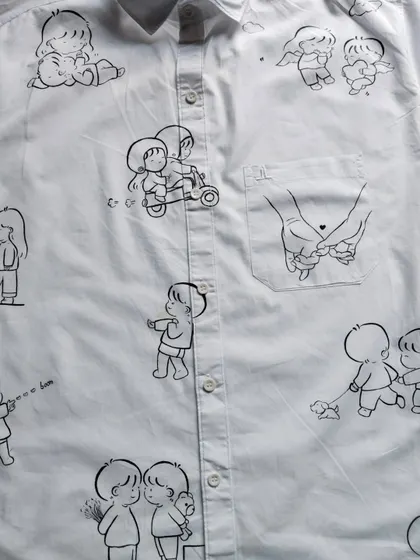 A closer look at the details on the custom doodle shirt, including the hand-holding design on the pocket. Every illustration is placed thoughtfully to create a balanced and beautiful composition.