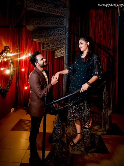 For couples who prefer a more dramatic and stylish theme, we offer indoor pre-wedding shoots. This shot uses moody lighting and an elegant spiral staircase to create a sophisticated, cinematic feel.