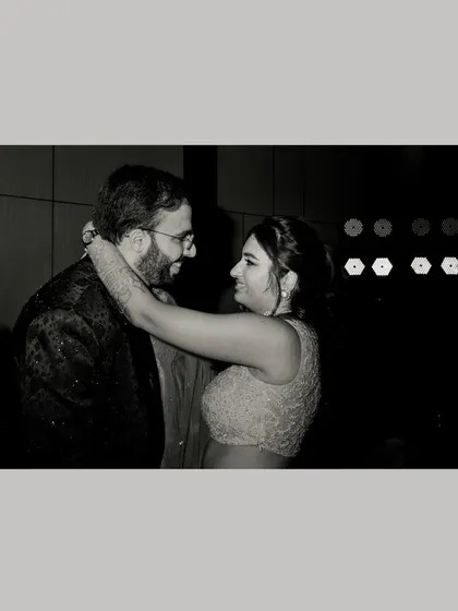 An intimate black and white photo of the couple embracing on the dance floor, capturing a quiet moment in the midst of the celebration.