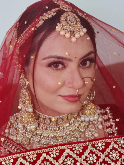 Another beautiful bride with a traditional nath and heavy jewelry, complemented by classic bridal makeup.