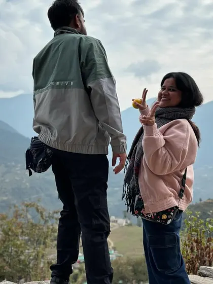 A candid moment of fun between two travelers against the backdrop of the mountains near Deoriatal. It's these small moments that make a trip special.