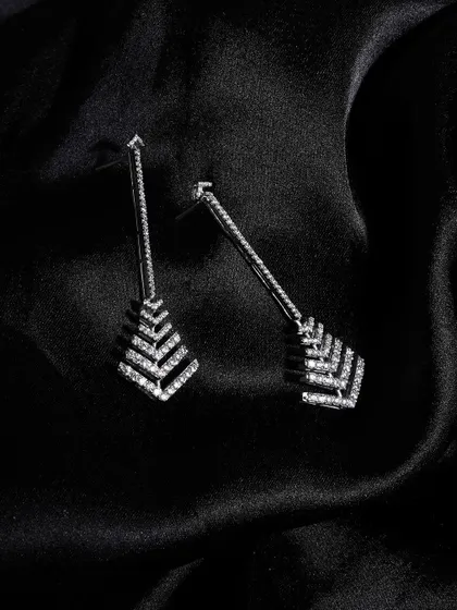 The epitome of elegance. These art-deco-inspired diamond earrings are shot on black silk, allowing their geometric design and brilliant sparkle to be the absolute focus.