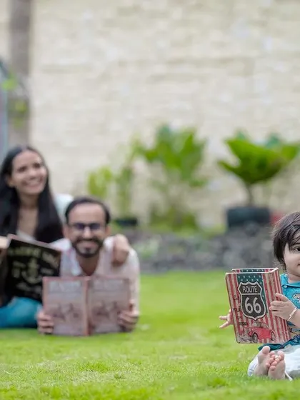 We love capturing a child's world. This shot focuses on the baby boy and his book, with his parents blurred lovingly in the background, telling a story of family and learning.