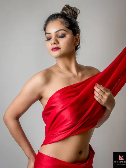 A similar pose from the 'Crimson Dreams' series, with the model's eyes closed. The focus is on the texture of the red fabric and the graceful lines of her body.