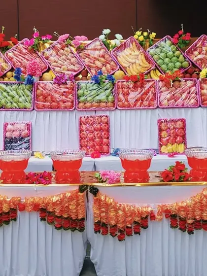 A grand fruit counter display, showcasing a wide variety of fresh fruits and juices. This kind of setup can be a beautiful and healthy centerpiece for your event.