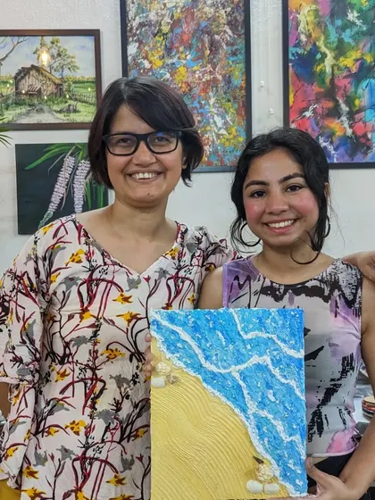 Our founder, Nisha, with a participant and her stunning beach-themed texture painting. The texture paste creates realistic waves and sand.