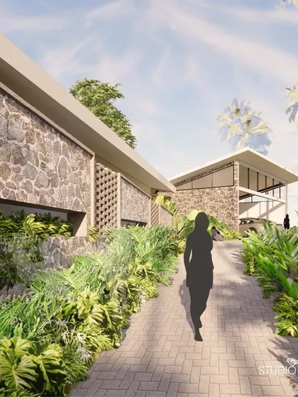 A ramped entrance path, flanked by lush tropical planting and a random rubble stone wall, leads visitors into the property. This gradual, landscaped approach creates a sense of journey and arrival.