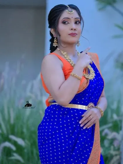 A model in a blue saree, with her hair styled in a textured, braided ponytail for a photoshoot.