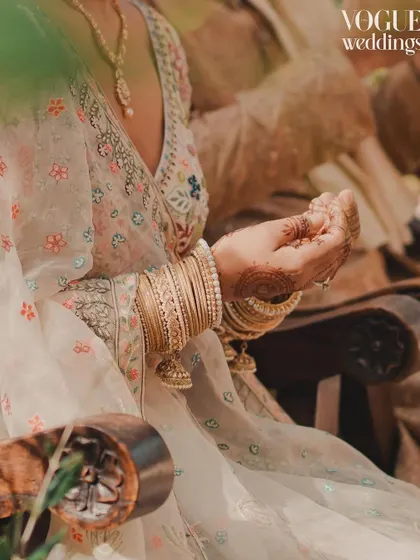 A close-up of the bride's hands during a ritual, a detail that tells a story of tradition and grace, featured in Vogue.