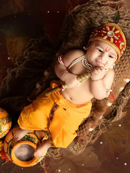 An artistic overhead shot of a baby Krishna, surrounded by decorated pots. This composition creates a beautiful and unique perspective.