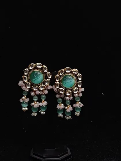 These unique earrings feature carved green stones surrounded by Polki. A subtle yet stylish rental choice.