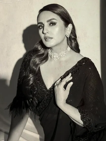 A classic black and white portrait that exudes elegance. The focus is on the sparkling choker, the feather details on the blouse, and the timeless beauty of the wearer.