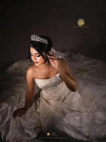 A dramatic portrait of the bride. The lighting beautifully captures the intricate details of the tiara and the gown's bodice.