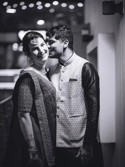 A candid black and white photo of a groom whispering to his bride. These unscripted moments are often the most precious.