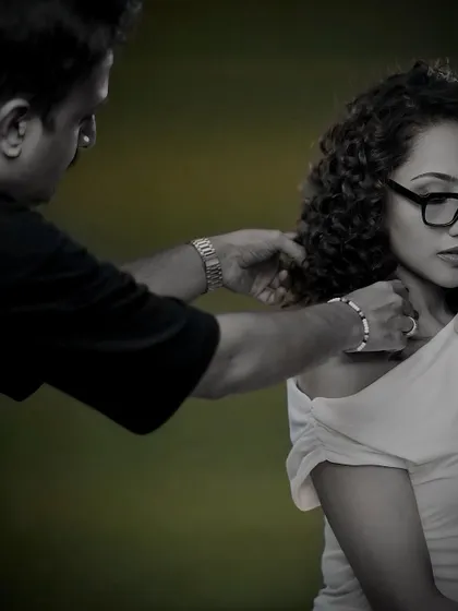 A color-splash photo of a stylist making final adjustments to the model's curls.