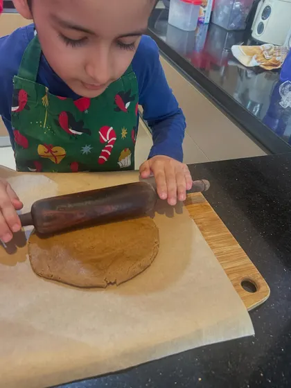 Rolling out the gingerbread dough. Each step of the process requires focus and precision, teaching valuable life skills in a gentle, enjoyable way.