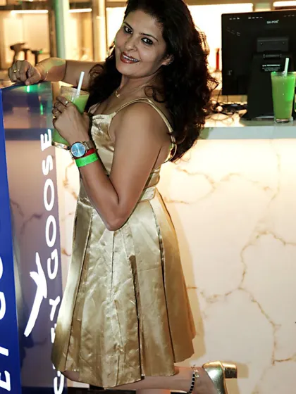 Posing at the bar in my golden satin birthday dress, a fun and flirty custom design.