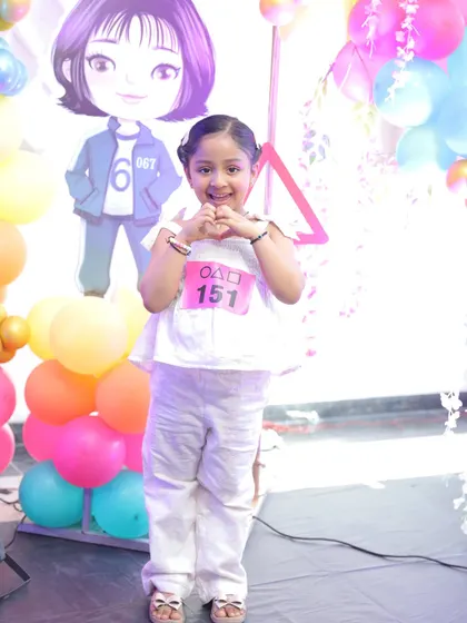A happy little guest dressed up for the 'Squid Fiesta' birthday party. It's always a joy to see children enjoying the immersive themes I create, complete with fun details like player numbers.