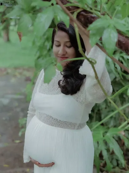 Peeking through the leaves, this creative shot adds a sense of intimacy and connection with nature. It’s a lovely way to frame a solo maternity photo.