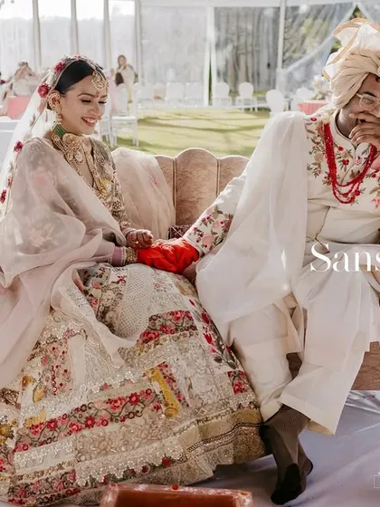 A magazine-style shot of the couple seated during their Ooty wedding, capturing a candid moment of them sharing a laugh.